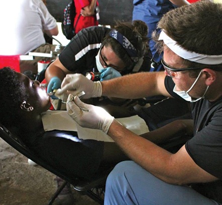 Dr. Shane with a young patient and a volunteer in Belize