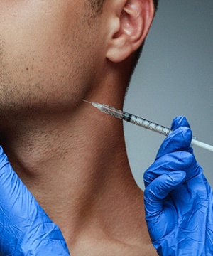 Dentist placing BOTOX injection into patient's jaw