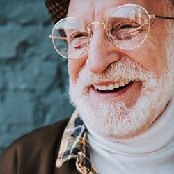 An older man with a dental implant in Jupiter smiling