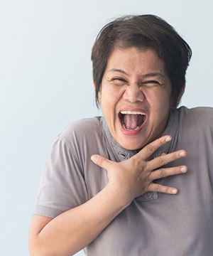 smiling person with their hand on their chest