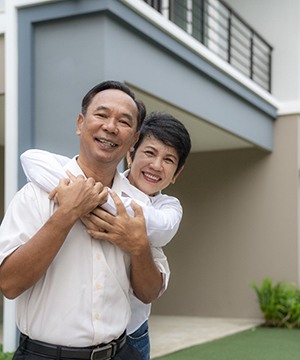 couple standing in front of their house