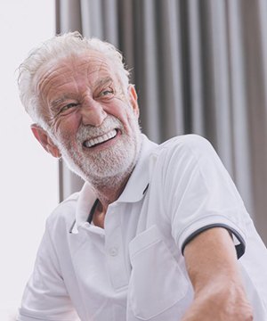 a man smiling after receiving his new dentures