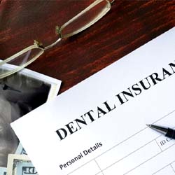 Insurance paperwork on wooden desk with dental X-ray