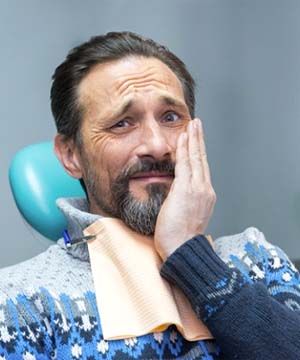 Man with toothache listening to the cost of dental emergencies in Jupiter