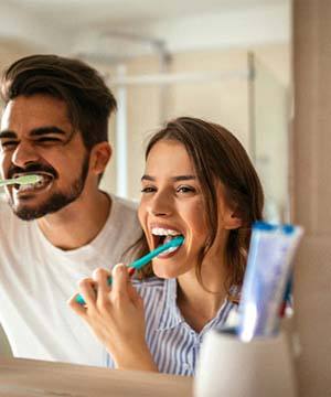 Couple brushing to avoid toothaches in Jupiter