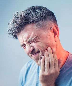 a person holding their mouth because of tooth pain