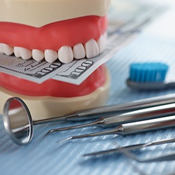 Money and tooth mold and dental instruments in Jupiter