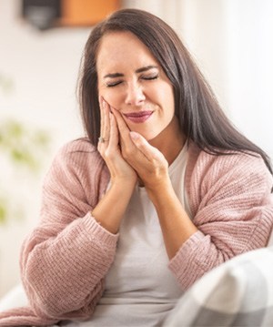 Woman sitting on couch with oral pain