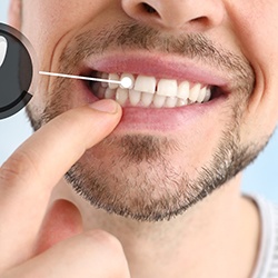 A man pointing to his single dental implant