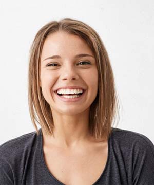 young woman smiling with straight teeth thanks to Invisalign in Jupiter, FL