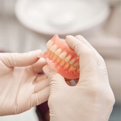 a person holding a pair of newly created dentures 