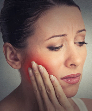 Woman experiencing tooth pain in Jupiter