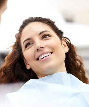 A young female smiles as she listens to her dentist explain the process for scaling and root planing in Jupiter