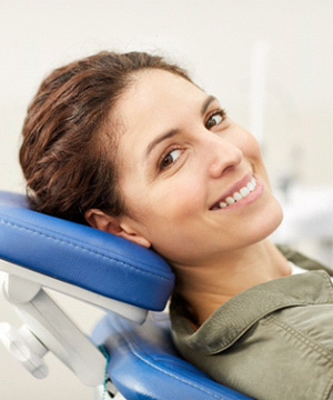 Woman sitting back in chair smiling before sedation dentistry in Jupiter, FL