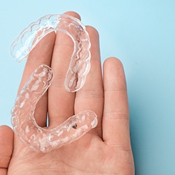 Bird’s eye view of two clear aligners resting on palm of hand