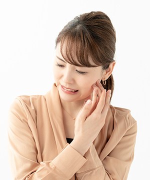Woman with facial pain, experiencing symptoms of TMJ disorder
