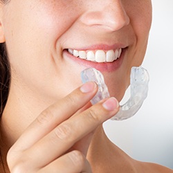 Close-up of patient holding occlusal splint for teeth grinding and TMD