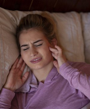 Woman in bed with jaw pain