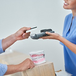 A patient paying the cost of teeth whitening