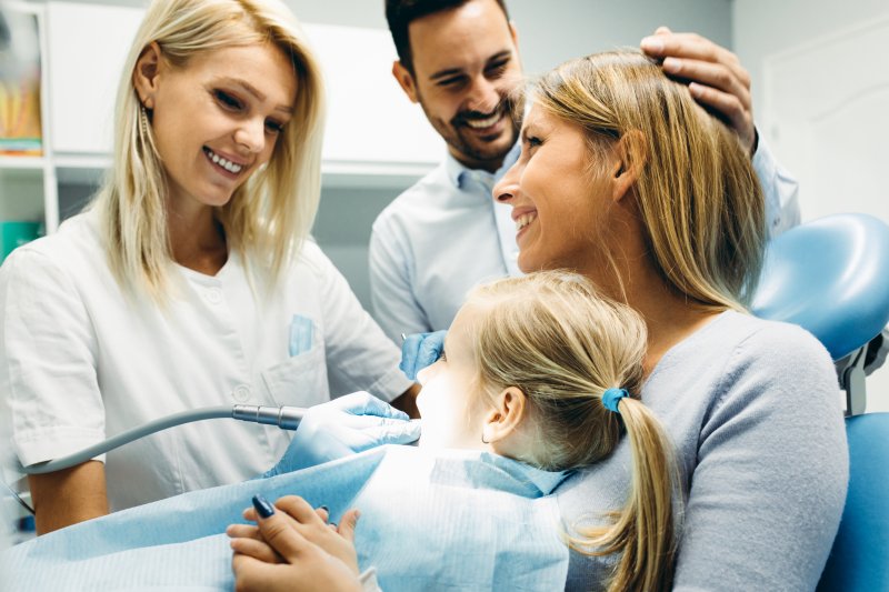 Family smiling at child's dentist appointment