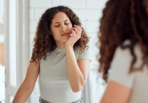 a woman who has irritated gums from brushing too hard